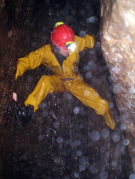 Ian Cummins scaling the waterfall in Ling Gill Cave